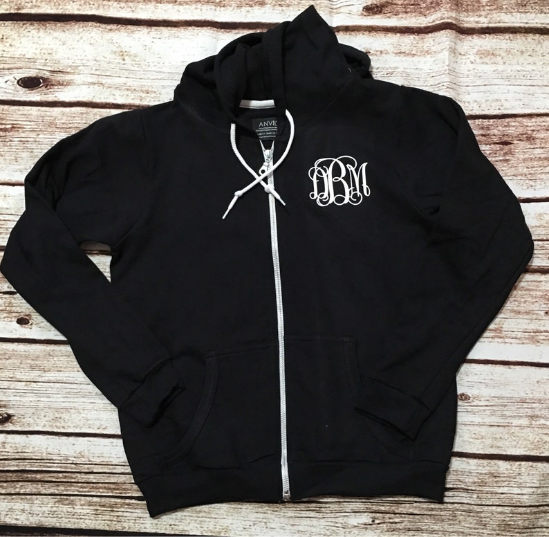 May include: Black zip-up hoodie with a white monogram "DBM" on the front.
