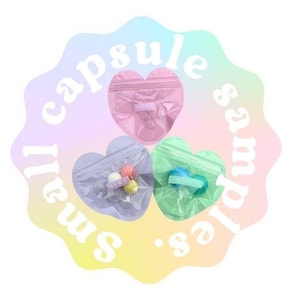May include: Three heart-shaped plastic bags with small samples inside. The bags are labeled "Small Capsule Samples".