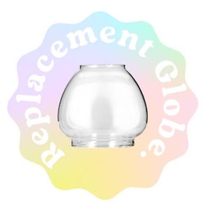 Puede incluir: Globo de repuesto de vidrio transparente para una lámpara. El globo es redondo y tiene una superficie lisa.