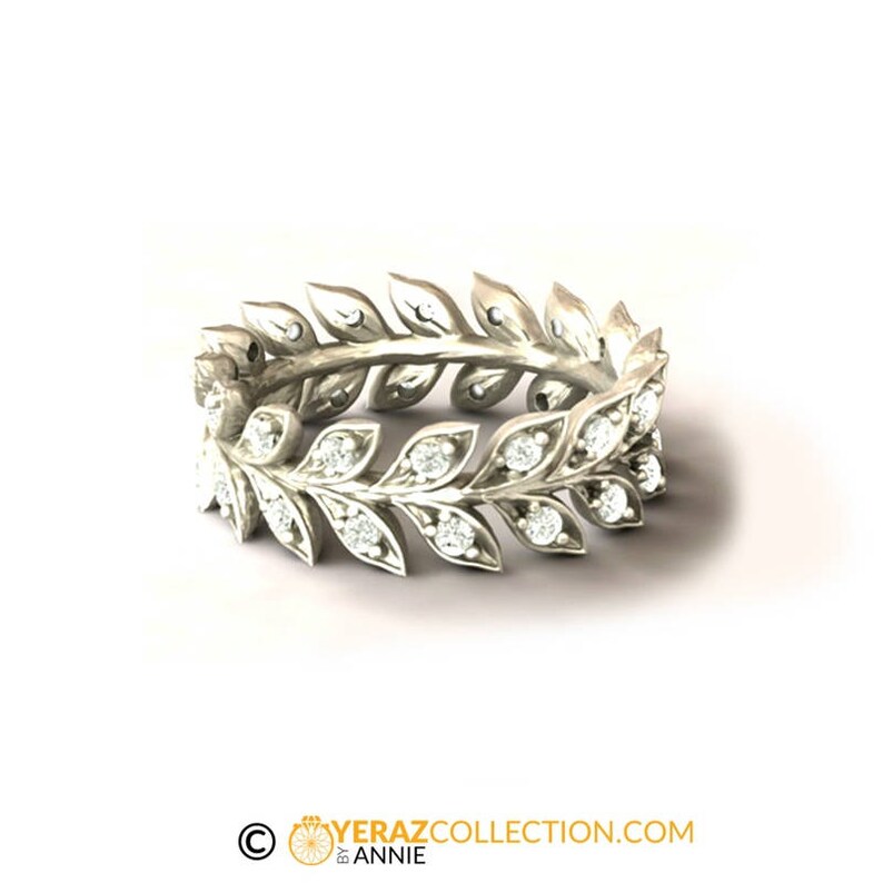 May include: A silver ring with a delicate design of leaves and small diamonds. The ring is a simple and elegant piece of jewelry.