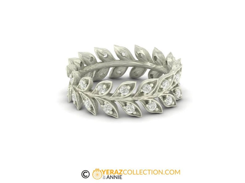 May include: A silver ring with a delicate design of leaves and small diamonds.