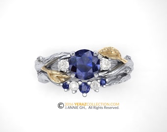 Puede incluir: Un anillo de plata y oro con un zafiro azul y diamantes engastados en una banda con forma de rama. El anillo tiene un diseño de hoja en el lateral.