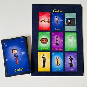 May include: A set of playing cards featuring characters and objects from the movie Coraline. The cards are blue, green, purple, and yellow with stars and the names of the characters and objects printed on them. The cards are arranged in a grid on a black background.