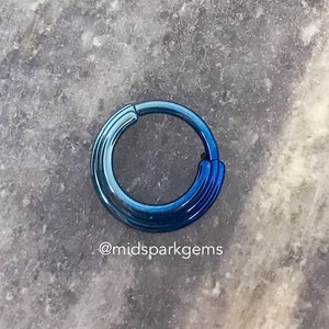May include: A blue and green titanium seamless ring, also known as a captive bead ring, for body piercing. The ring is made of surgical grade titanium and is available in a variety of sizes.