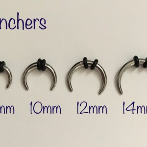May include: Four silver 12 gauge septum rings with black rubber o-rings. The rings are 8mm, 10mm, 12mm, and 14mm in diameter.