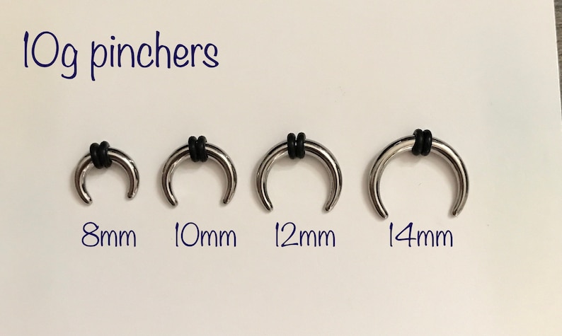 May include: Four silver hoop earrings with black rubber inserts. The hoops are 8mm, 10mm, 12mm, and 14mm in diameter.