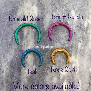 May include: Four different colored metal rings, in emerald green, bright purple, teal, and rose gold. The rings are all the same size and shape, and they are arranged in a square pattern. The text "@midsparkgems" is written below the rings. The text "More colors available!" is written below the text "@midsparkgems".