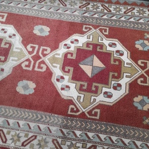May include: A red, white, and blue patterned rug with a geometric design. The rug has a traditional Turkish kilim style.