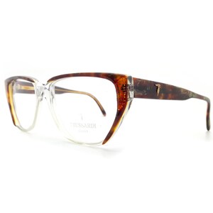 May include: Tortoiseshell eyeglasses with clear lenses and a gold-tone logo that says " Trussardi Milano".