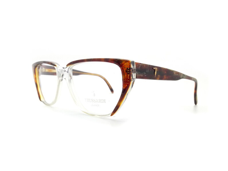 May include: Tortoiseshell eyeglasses with clear lenses and a gold-tone logo that says " Trussardi Milano".