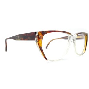 May include: A pair of tortoiseshell eyeglasses with clear lenses and a cat-eye shape.