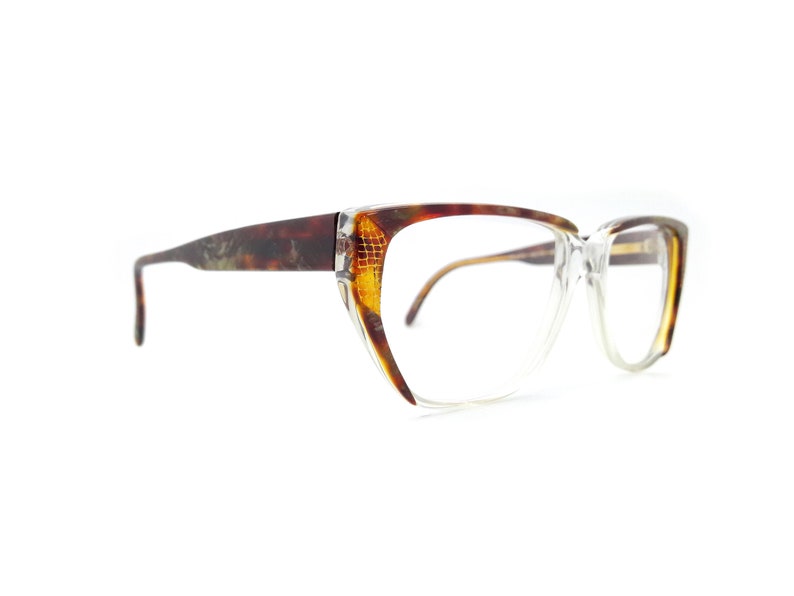 May include: A pair of tortoiseshell eyeglasses with clear lenses and a cat-eye shape.