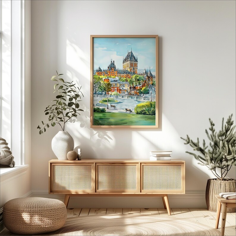 May include: A framed watercolor painting of a cityscape featuring a large castle with multiple spired towers. The painting has a light wood frame and is displayed above a wooden cabinet with woven cane doors. The scene includes green grass, trees, and benches.