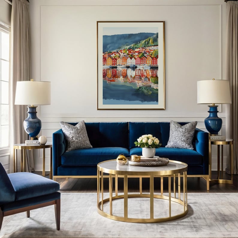 May include: A living room with a navy blue velvet sofa, two matching side tables with blue lamps, and a gold-framed coffee table. A framed watercolor painting of a colorful waterfront scene hangs above the sofa. Decorative pillows and a rug complete the space.
