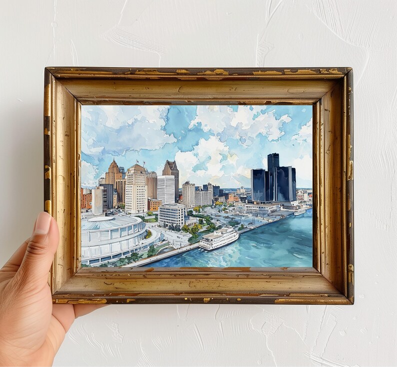 以下が含まれることがあります： 金色のフレームに入った都市景観の水彩画。このアートワークは、建物、大きな白い構造物、フェリーのあるウォーターフロントのシーンを描いています。空は青く、ふわふわの白い雲があります。フレームは、使い古されたアンティークな外観をしています。