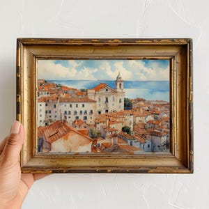 Lisbon_Alfama_watercolor_painting_placed_inside_an_antique_wooden_frame_with_gold_accents_on_the_edges