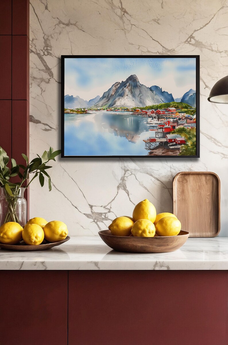 May include: A framed watercolor painting depicts a mountain landscape with a village by a lake. The painting is above a countertop with lemons in wooden bowls. A wooden tray and a vase with greenery are also on the counter.