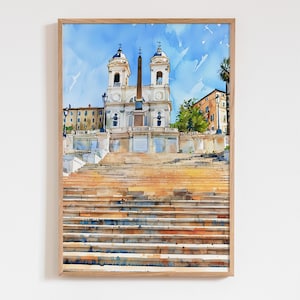 May include: Watercolor painting of the Spanish Steps in Rome, Italy, framed in a light wood. The artwork depicts the steps leading up to a church with two bell towers, a tall obelisk, and buildings under a blue sky.