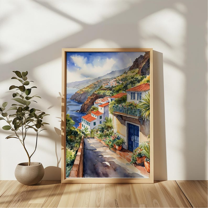 May include: Watercolor painting of a coastal village with white houses and red tile roofs. The houses are built on a hillside overlooking a blue ocean. A winding road leads up to the houses, with lush green vegetation on either side.