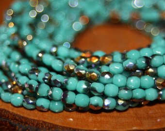 Op de afbeelding: Een close-up van een turquoise en zilveren kralenketting. De kralen zijn gefacetteerd en hebben een glinsterende afwerking.