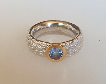 wide silver ring with light blue sapphire stone