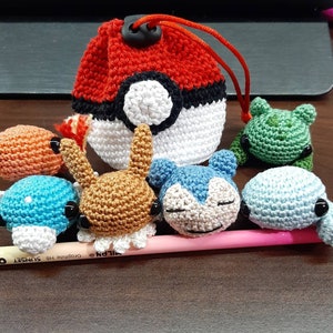 Może przedstawiać: Kolekcja postaci Pokemonów wykonanych na szydełku, w tym Bulbasaur, Squirtle, Charmander i Pikachu. Postacie są w różnych pozach i wykonane z przędzy w różnych kolorach. Jest też szydełkowa Pokeball.