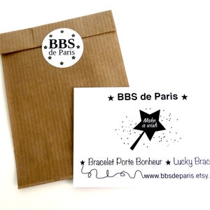 May include: A white card with black text and a black star design. The text reads "★ BBS de Paris ★", "Make a wish", "Bracelet Porte Bonheur ★ Lucky Bracelet", and "www.bbsdeparis.etsy.com".