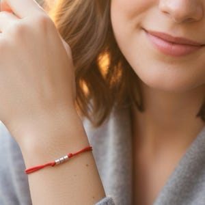 Armband med 3 rörpärlor i 925 sterlingsilver på en röd snodd. Skyddande smycken till ett lågt pris.