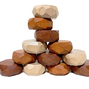 May include: A stack of 10 wooden geometric shapes in brown, light brown, and natural wood tones. The shapes are stacked in a pyramid formation.