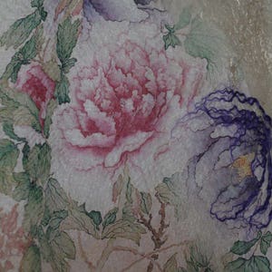K&ouml;nnte beinhalten: Nahaufnahme eines floralen Designs mit gro&szlig;en, detaillierten Pfingstrosenbl&uuml;ten in Rosa- und Lilat&ouml;nen. Gr&uuml;ne Bl&auml;tter und Stiele sind mit den Bl&uuml;ten verwoben, wodurch eine zarte und k&uuml;nstlerische Komposition entsteht. Der Hintergrund ist ein weiches, strukturiertes Off-White.