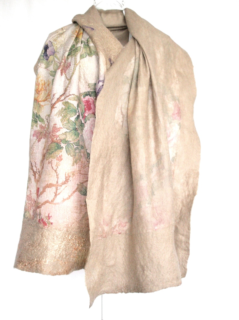 K&ouml;nnte beinhalten: Beiges Schal- und Mantel-Set. Der Mantel hat ein Blumenmuster mit rosa, gelben und lila Blumen auf cremefarbenem Hintergrund. Der Schal ist einfarbig beige mit einem dezenten Blumendesign.