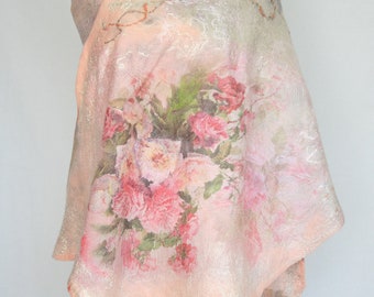 Könnte beinhalten: Ein blassrosa Schal mit einem Blumendruck aus rosa und weißen Rosen und grünen Blättern. Der Schal ist aus einem weichen, strukturierten Stoff gefertigt und hat eine fließende, asymmetrische Form.