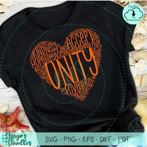 Puede incluir: Una camiseta negra con un diseño en forma de corazón naranja. El corazón está lleno de palabras como "unidad", "amor", "paz", "esperanza", "amabilidad" y "aceptar".