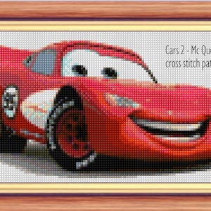 Pode incluir: Padrão de ponto cruz de um carro de corrida vermelho de desenho animado com um rosto sorridente. O carro se chama "McQueen" e é do filme "Carros 2".