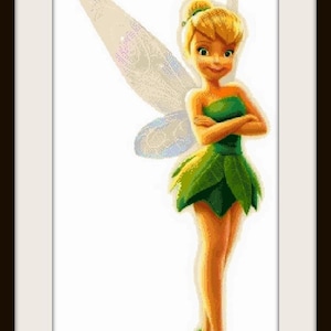 Puede incluir: Tinkerbell, un hada con cabello rubio y alas verdes, lleva un vestido verde y está de pie con los brazos cruzados. La imagen está titulada "Neni Design" y "Tinkerbell".