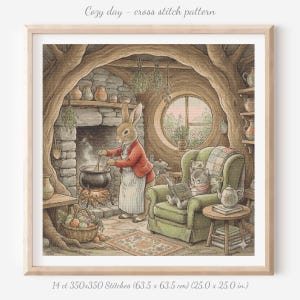 以下が含まれることがあります： 「Cozy day」と題されたクロスステッチパターン。赤いジャケットを着たウサギが火の上で鍋をかき混ぜています。猫が緑のアームチェアで本を読んでいます。額入りのアートワークのサイズは63.5 x 63.5 cmで、14 ct、350x350ステッチです。