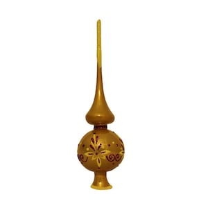 Pode incluir: Topo de árvore de Natal de vidro dourado com uma ponta pontiaguda e uma base redonda. A base é decorada com um desenho floral amarelo e vermelho.