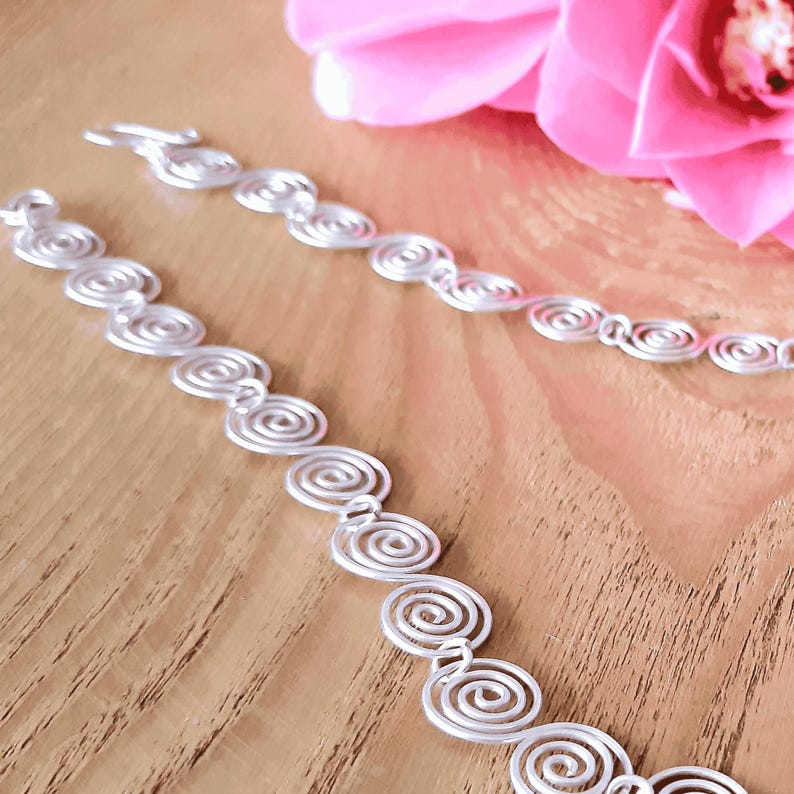 Close up details of the Celtic Silver spiral necklace on a wooden surface