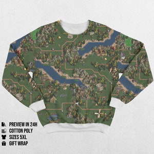 Può includere: Una felpa a maniche lunghe con un design dettagliato della mappa, con fiumi, montagne ed edifici in tonalità di verde, blu e marrone. La felpa ha polsini bianchi e un colletto bianco. Il tema è una mappa fantasy o avventura.