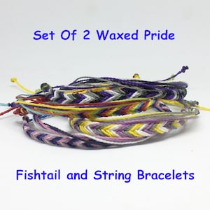 Pode incluir: Conjunto de duas pulseiras de corda e cauda de peixe com orgulho encerado, em várias cores, incluindo roxo, amarelo, branco, cinza e preto.