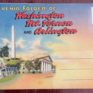 May include: Vintage souvenir postcard featuring illustrations of Washington, Mt. Vernon, and Arlington landmarks. The postcard has a colorful design with a white obelisk, buildings, and the text "Souvenir Folder of Washington Mt. Vernon and Arlington."