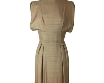May include: A vintage beige dress with a fitted waist and pleated skirt. The dress features short, cap-style sleeves and a subtle sheen, suggesting a silk or similar fabric. The overall design is classic and elegant.