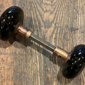 Schwarze Porzellan Türknäufe mit Messing Schäften.  Kupferfarben.  Antikes viktorianisches.