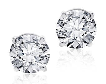 May include: A pair of silver stud earrings with clear round cubic zirconia stones.