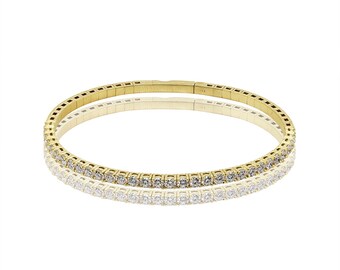 May include: A gold bracelet with a row of small diamonds around the edge.
