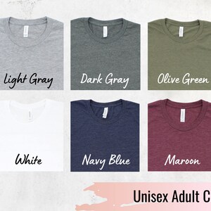 May include: A selection of unisex adult crew neck t-shirts in various colors, including black, light gray, dark gray, olive green, mauve, dusty blue, white, navy blue, maroon, and mustard.  Unisex Adult Crew Neck Colors.