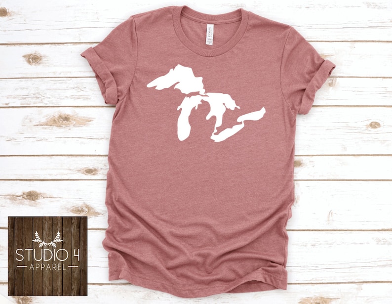 May include: A mauve coloured t-shirt with a white outline of the Great Lakes on the front. The shirt is made of a soft, comfortable material and has a crew neck.