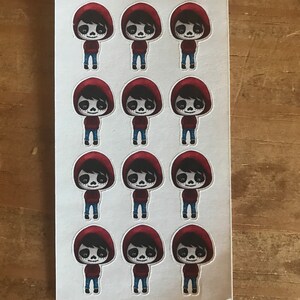 May include: Sheet of stickers featuring a cartoon character with a skull face, wearing a red hooded sweatshirt and blue jeans. The stickers are on a white background, with the text "Danny's Planner Cuties" at the top.