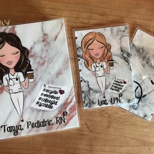 May include: Two clear plastic covers with marble patterns. The left cover has a cartoon illustration of a nurse holding a coffee cup and the text "Tanya, Pediatric RN". The right cover has a stethoscope and the text "Lexi LPN".