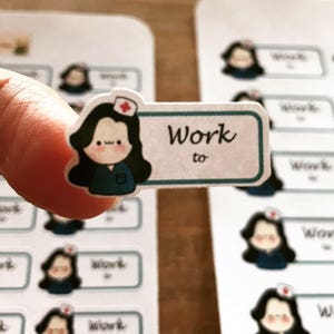 May include: A set of stickers featuring a cartoon nurse with the text "Work to" on a teal banner. The stickers are printed on white paper.